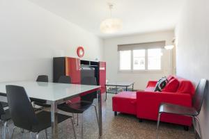 sala de estar con mesa y sofá rojo en Pubone AT Barberà del Valles, en Barberà del Vallès