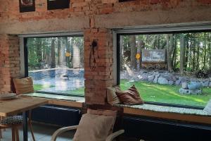 twee ramen in een kamer met een tafel en een zwembad bij Depo Loco ( Banícke depo) in Špania Dolina