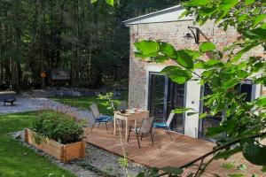 een houten terras met stoelen en een tafel in een tuin bij Depo Loco ( Banícke depo) in Špania Dolina