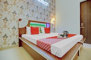 um quarto com uma cama grande e almofadas vermelhas em OYO Three Kings em Ludhiana