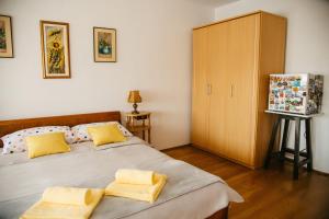 a bedroom with two beds with yellow pillows at Soba Gloria in Slavonski Brod