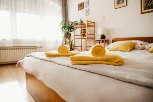 a bedroom with two beds with yellow towels on them at Soba Gloria in Slavonski Brod