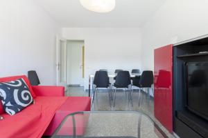 ein Wohnzimmer mit einem roten Sofa, einem Tisch und Stühlen in der Unterkunft Pubone AT Barberà del Valles in Barberà del Vallès