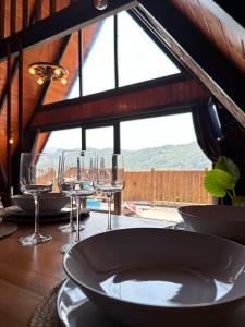 a table with wine glasses and a plate on it at Sapanca360bungalows in Sakarya