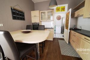 eine Küche mit einem Holztisch und Stühlen im Zimmer in der Unterkunft The House of Monthléry Comfort in Limoges in Limoges