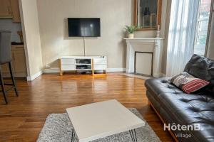 ein Wohnzimmer mit einem Sofa und einem TV in der Unterkunft The House of Monthléry Comfort in Limoges in Limoges