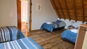 a room with two beds and a wooden floor at KILKA's in Caviahue
