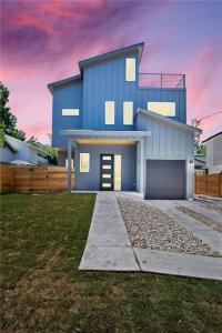 a large blue house with a driveway in a yard at East Austintacious: walkable airy arty 4 bedroom 3 1/2 bath in Austin