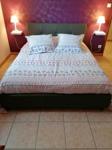 een bed in een slaapkamer met 2 lampen op tafels bij AIR PAIX LE MONT in Herpelmont