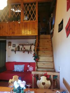 a living room with a red couch and stairs at Pichi's House in Cesuna