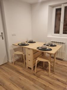 una mesa y sillas de madera con platos y cuencos. en Le panier Vieux-Port Marseille, en Marsella