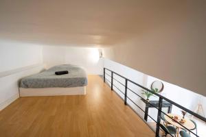 a bedroom with a bed and a wooden floor at Studio Mezzanine Aumône Vieille in Aix-en-Provence