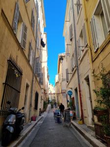 una persona caminando por un callejón estrecho con edificios en Le panier Vieux-Port Marseille, en Marsella