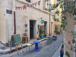 une rue avec des tables et des chaises sur le côté d'un bâtiment dans l'établissement Le panier Vieux-Port Marseille, à Marseille