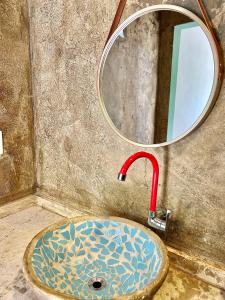 um lavatório de casa de banho com uma torneira e um espelho em Suíte em Sítio a 5 minutos da praia em Porto Seguro