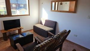 a living room with a couch and a chair and a television at KILKA's in Caviahue