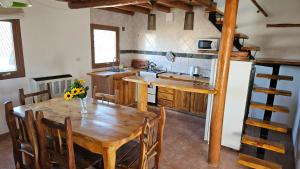 a kitchen with a wooden table and a kitchen with a sink at KILKA's in Caviahue