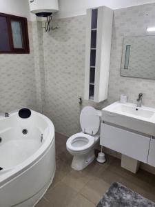 La salle de bains est pourvue d'une baignoire, de toilettes et d'un lavabo. dans l'établissement Appartement à couper de souffle, à Dakar