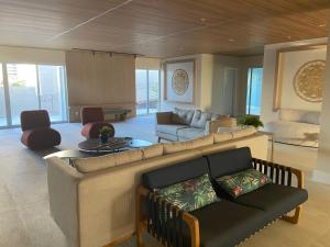 uma sala de estar com um sofá grande e uma sala de estar com em Acquarius Residence Vista Mar em Fortaleza