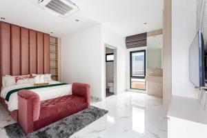 Astro Deluxe 4 Bedrooms Villa في Nong Prue: غرفة نوم بسرير احمر واريكة حمراء