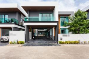 a building with a car parked in front of it at Astro Deluxe 4 Bedrooms Villa in Nong Prue
