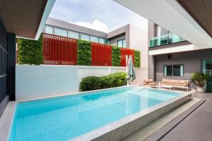 a swimming pool in the middle of a house at Astro Deluxe 4 Bedrooms Villa in Nong Prue