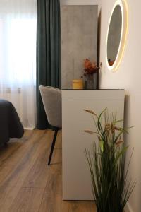 a room with a table and a chair and a mirror at Apartman Nila in Vukovar