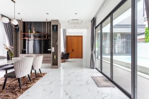 a kitchen and dining room with a table and chairs at Astro Deluxe 4 Bedrooms Villa in Nong Prue