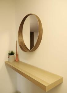 a wooden shelf with a mirror on a wall at Apartman Nila in Vukovar