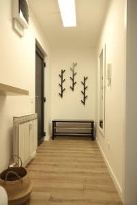a hallway with a bench on a wall with three branches on the wall at Apartman Nila in Vukovar