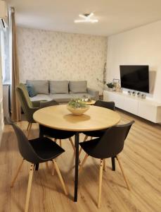 ein Wohnzimmer mit einem Tisch, Stühlen und einem Sofa in der Unterkunft Apartman Nila in Vukovar