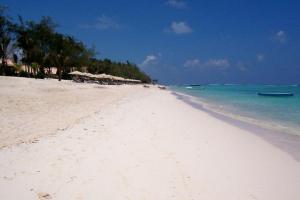- une plage de sable blanc avec des parasols et l'océan dans l'établissement Symon Belle Mare Lodge, à Belle Mare