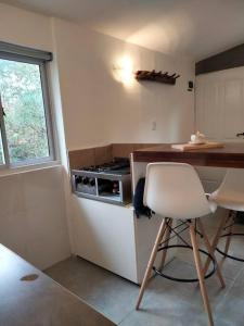 a kitchen with a stove and a counter with a chair at Lodge del Plata in Potrerillos