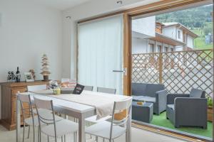 een witte tafel en stoelen in een kamer met een balkon bij Casa Bice in Bormio