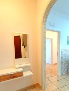 einen Flur mit einem Spiegel und Fliesenboden in der Unterkunft Imma's Mansion in Casalnuovo di Napoli