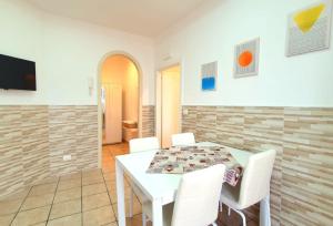 a dining room with a white table and white chairs at Imma's Mansion in Casalnuovo di Napoli