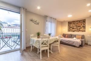 Habitación con mesa, cama y balcón. en Apartamento El Toisón de Oro 22 Garaje gratis en Bilbao