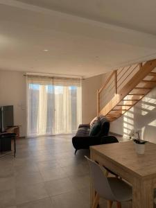 a living room with a couch and a staircase at Appartement dans une grange rénovée in Strasbourg