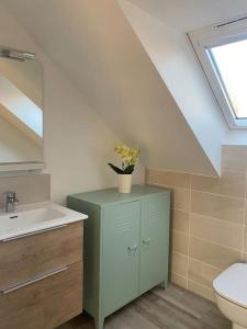 een badkamer met een wastafel, een toilet en een raam bij Appartement dans une grange rénovée in Straatsburg