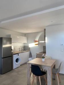 een keuken met een tafel en een keuken met een koelkast bij Appartement dans une grange rénovée in Straatsburg