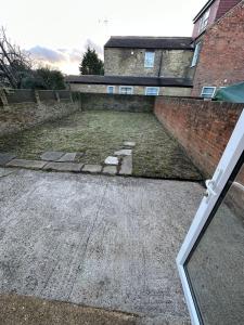 an empty parking lot in front of a brick building at Willesden Guest Room 130 in London