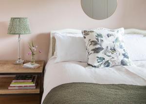 a bed with a pillow and a table with a lamp at Crescent Lodge, Crouch End, London in London