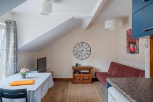 a living room with a couch and a clock on the wall at Apartment in city centre, close to bars and resturants in Belfast