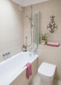 a bathroom with a tub and a toilet and a shower at Crescent Lodge, Crouch End, London in London