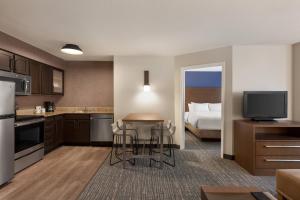 a kitchen with a room with a bed and a kitchen with a table at Residence Inn by Marriott Chicago / Bloomingdale in Bloomingdale