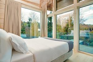 a bedroom with a bed and a large window at Eden Hill Retreat & Spa - Adults Only in Şimon