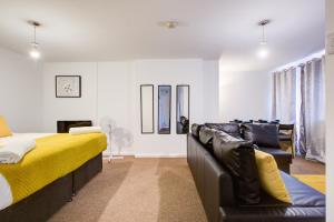 a bedroom with a bed and a couch at Town Centre Apartment in Croydon