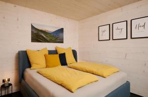a bed with yellow pillows in a room at Ferienwohnung HolzGenuss in Lehrberg