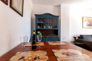 una mesa con dos copas de vino y un armario azul en PRIMERA LINEA, GRAN TERRAZA, MARAVILLOSAS VISTAS, ALTO standing, en Villajoyosa