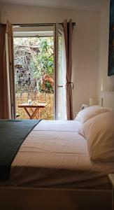 ブドヴァにあるBonaca Apartmentsのベッドルーム1室(ベッド1台付)、スライド式ガラスドアが備わります。
